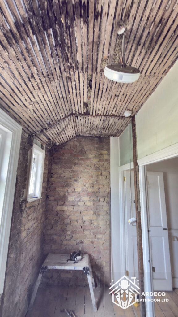 During renovation – walls stripped back to brick Exposed brick walls and stripped ceiling during deep replastering preparation in Northfields, Ealing