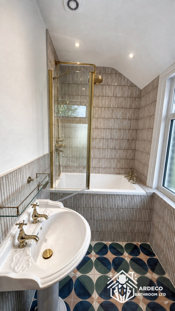 Finished combined bathroom and WC in Northfields, Ealing, with colourful patterned tiles and brass fittings